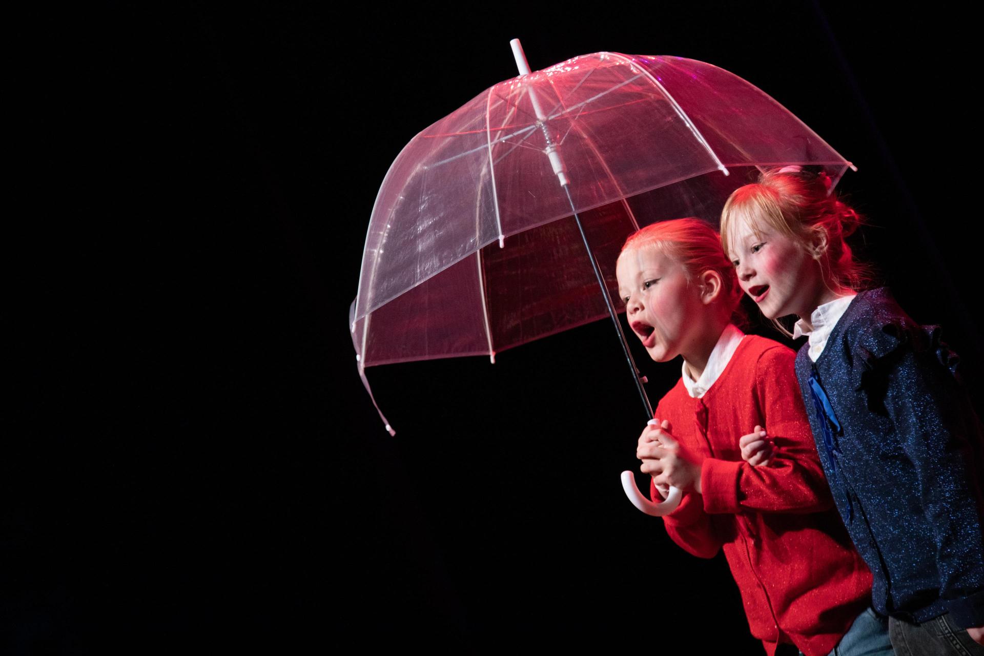 twee kinderen onder een paraplu
