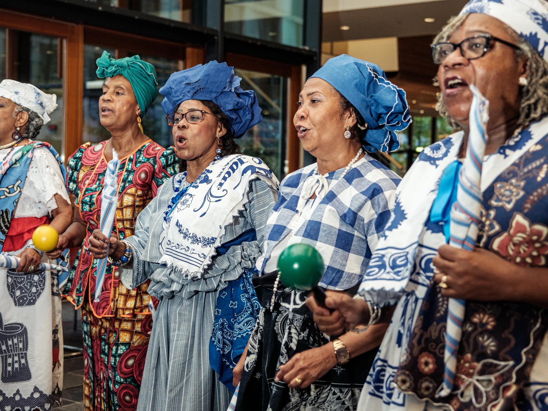 Vijf Surinaamse vrouwen zingen samen in een groep