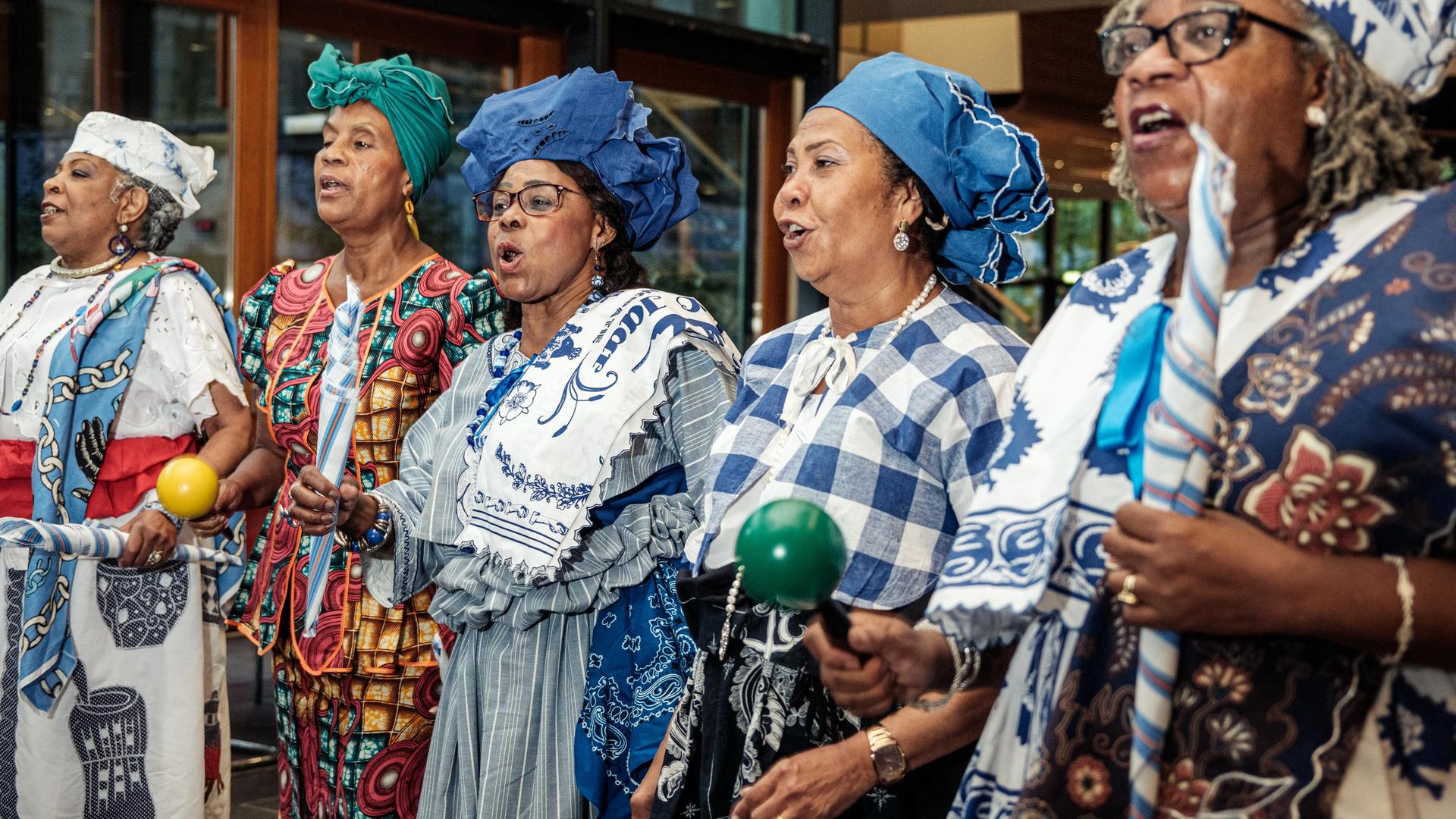 Vijf Surinaamse vrouwen zingen samen in een groep