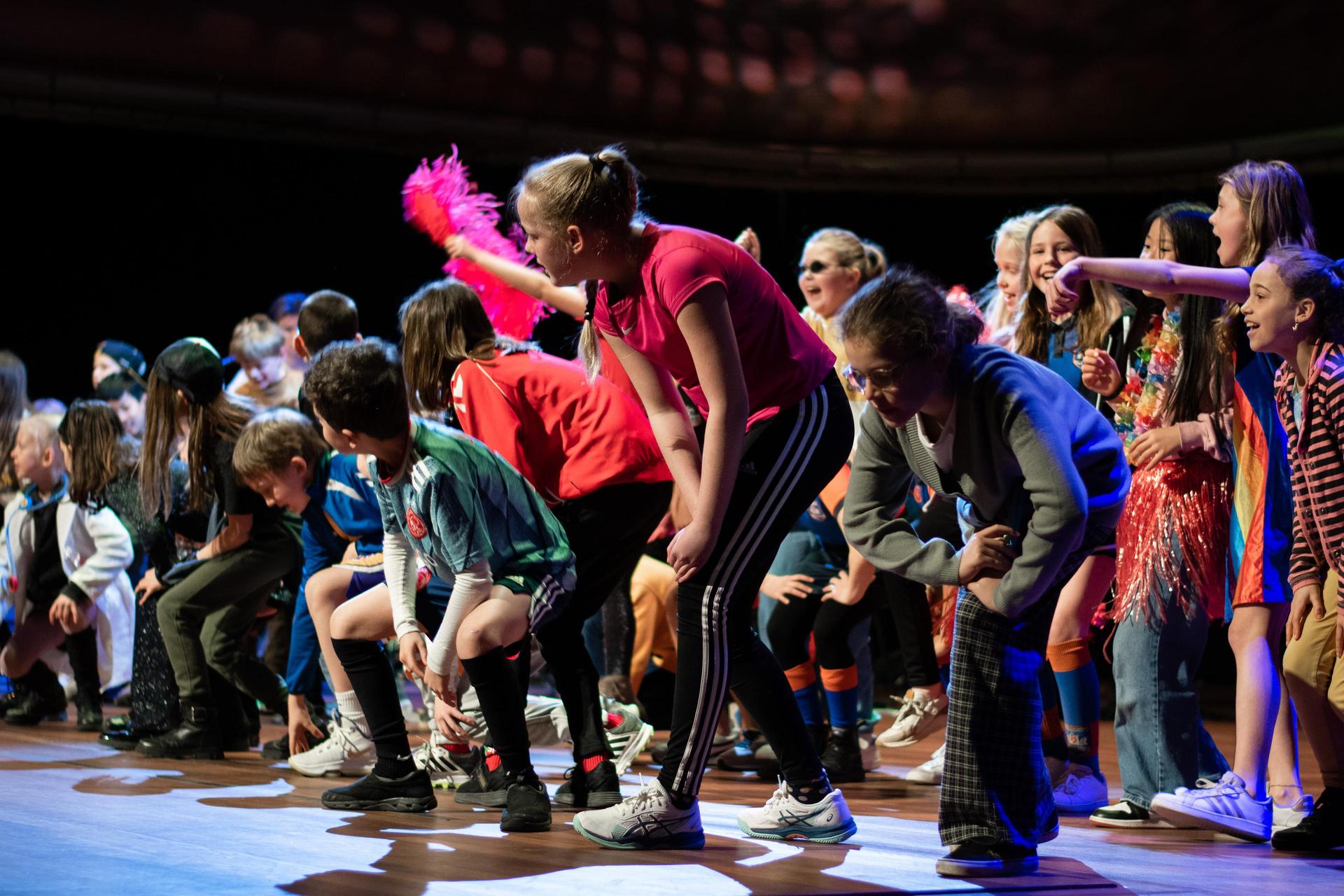 Kinderen staan in een grote groep op het podium