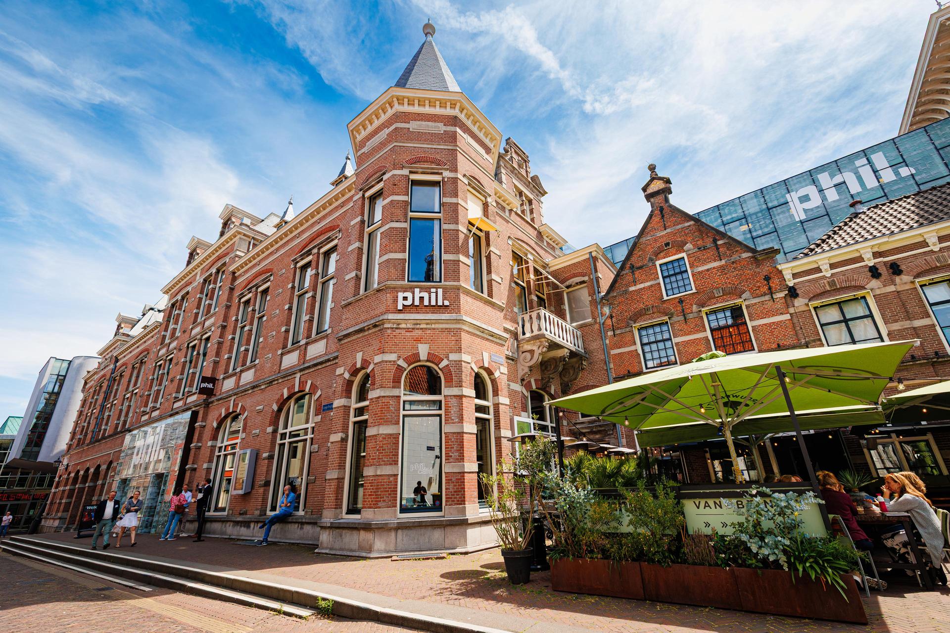 Buitenzijde van PHIL Haarlem met het terras van Brasserie Van Beinum ervoor 