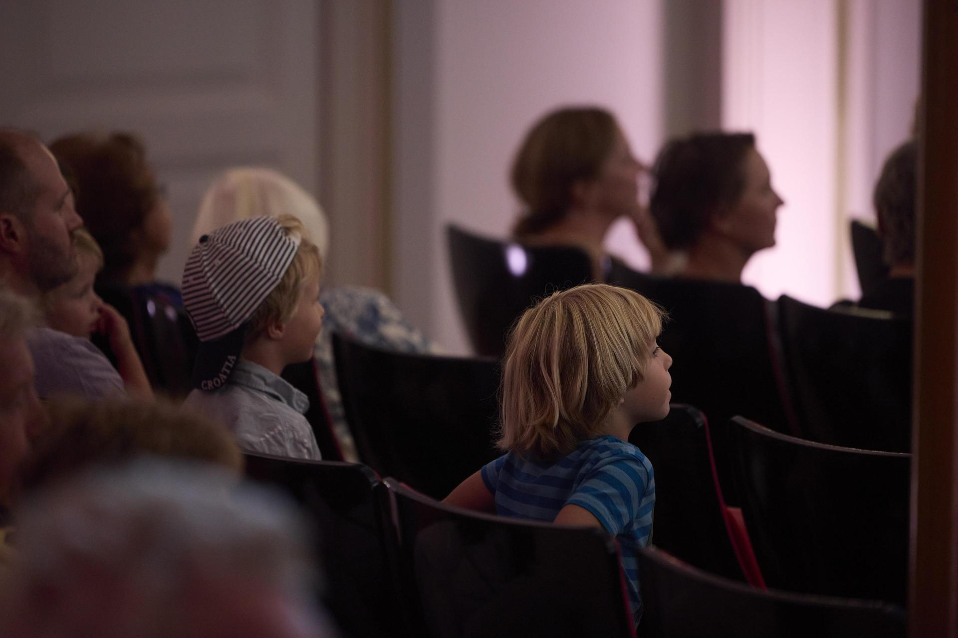 Jong kind zit in de Grote zaal