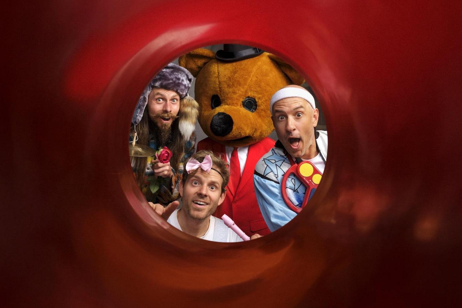 drie acteurs poseren met een knuffelbeer