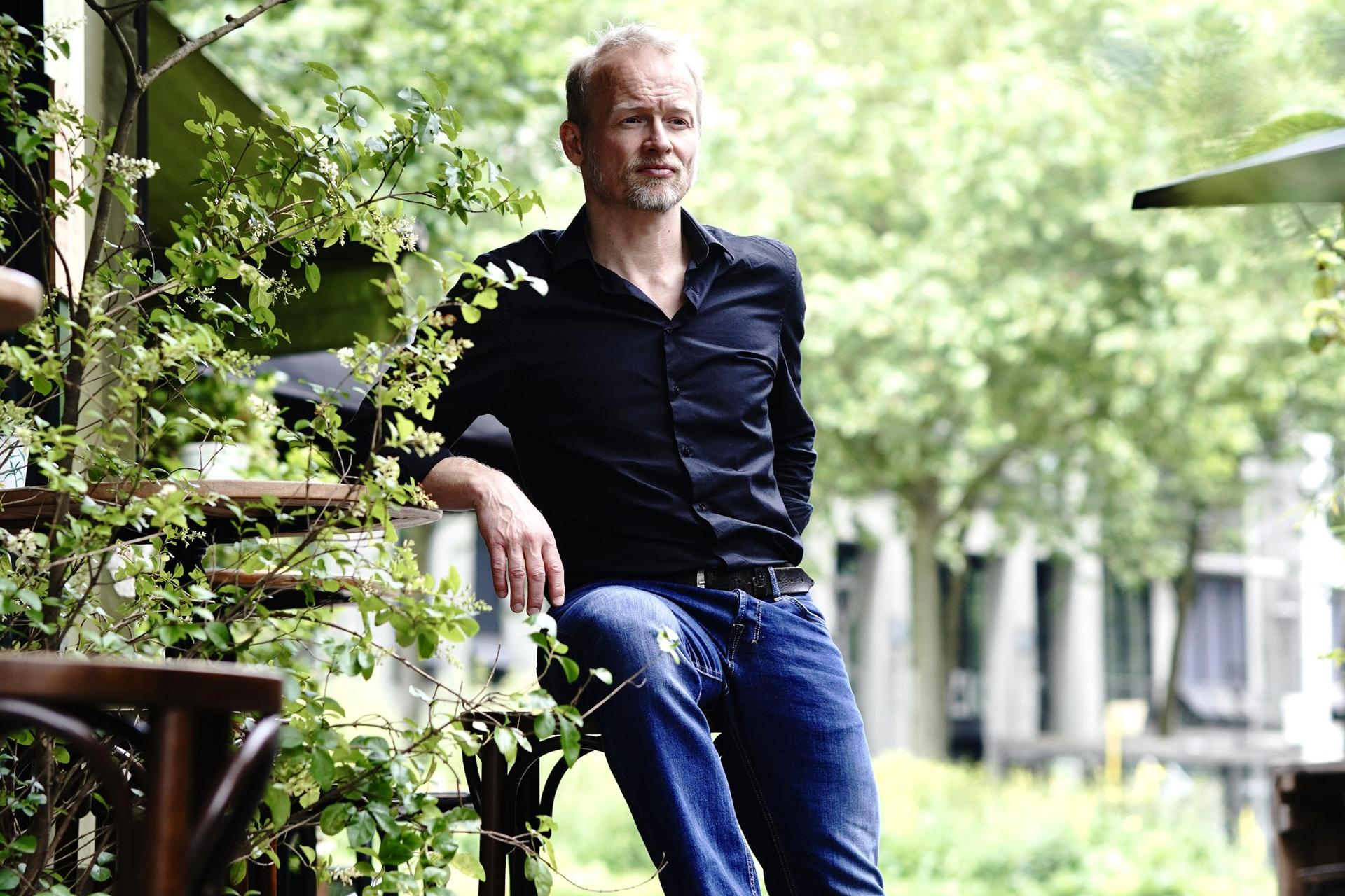 Diederik Nomden poseert buiten met zijn gitaar