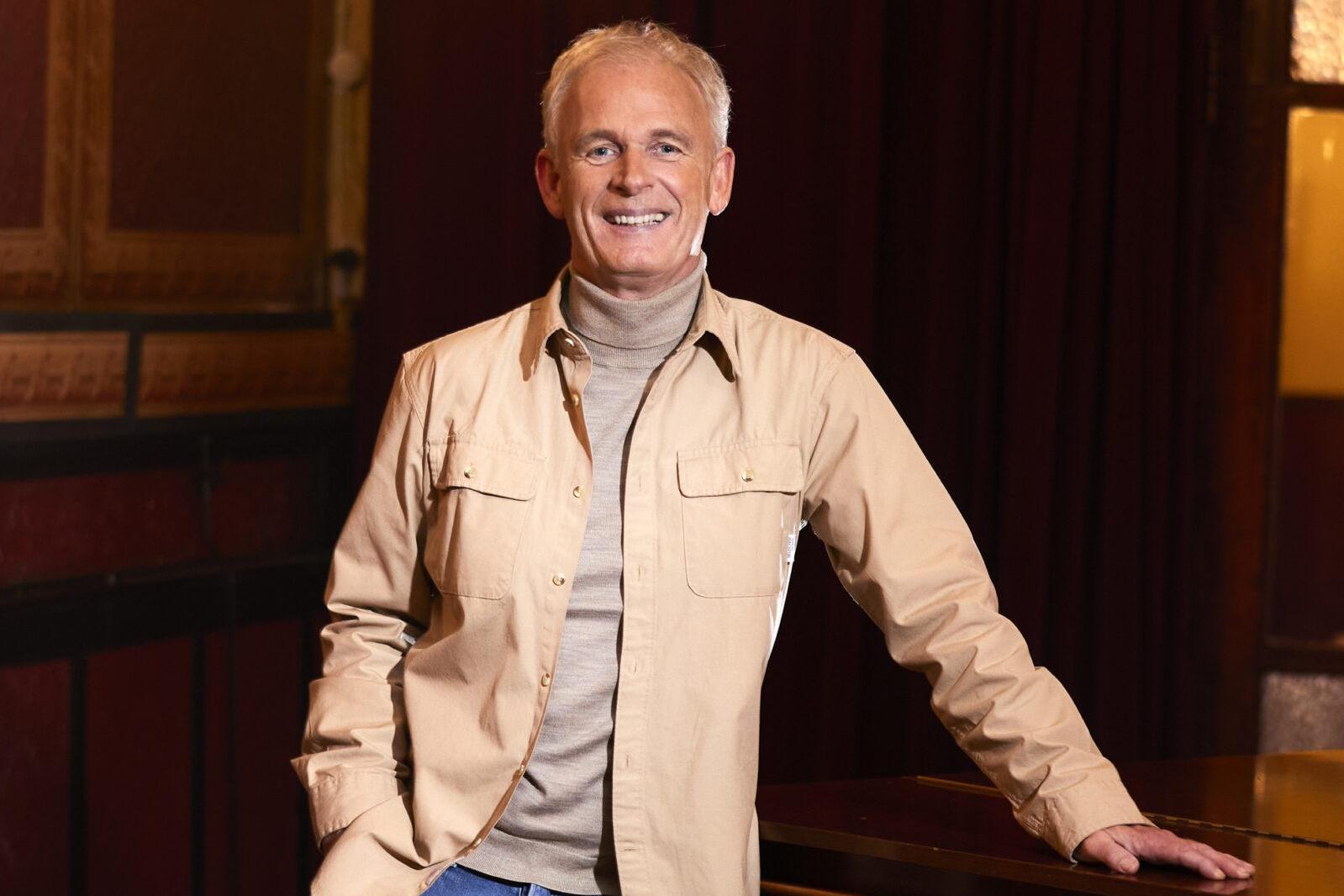Cor Bakker poseert bij zijn piano