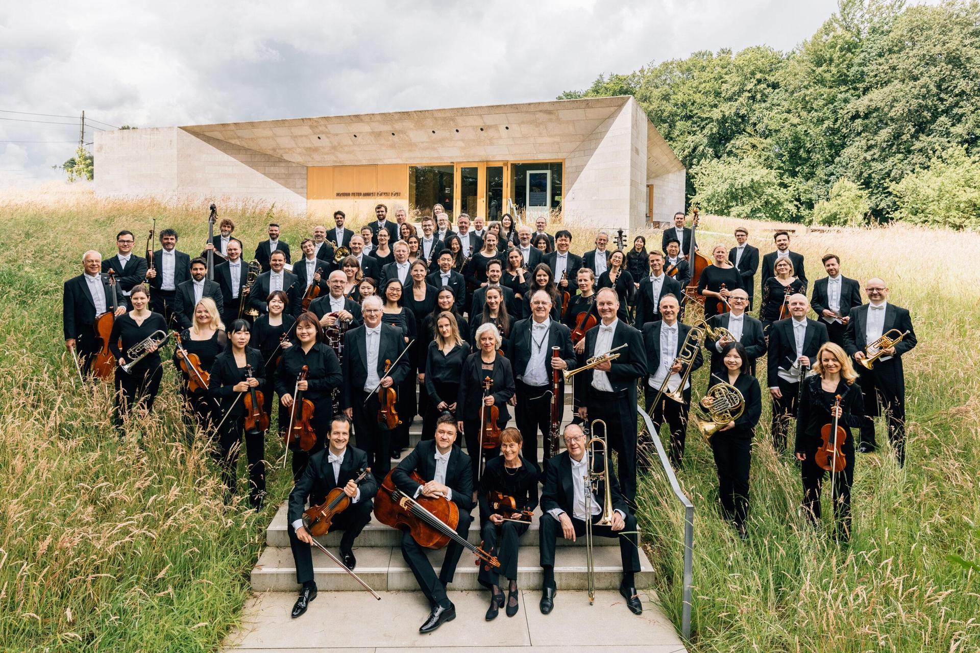 de Nordwestdeutsche Philharmonie poseert met hun instrumenten