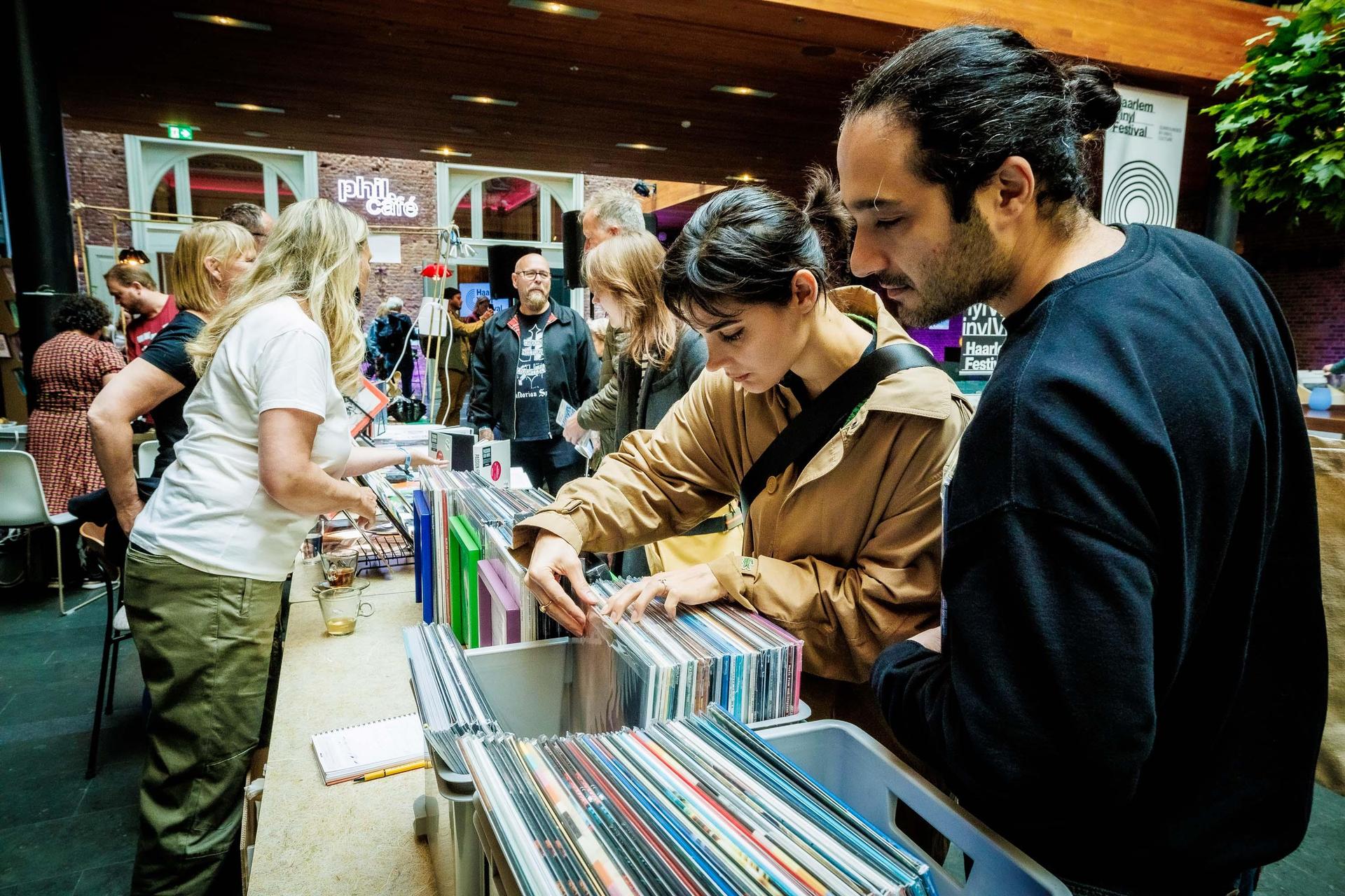 Gasten van het festival op de vinyl markt in de Grote Foyer van PHIL Haarlem