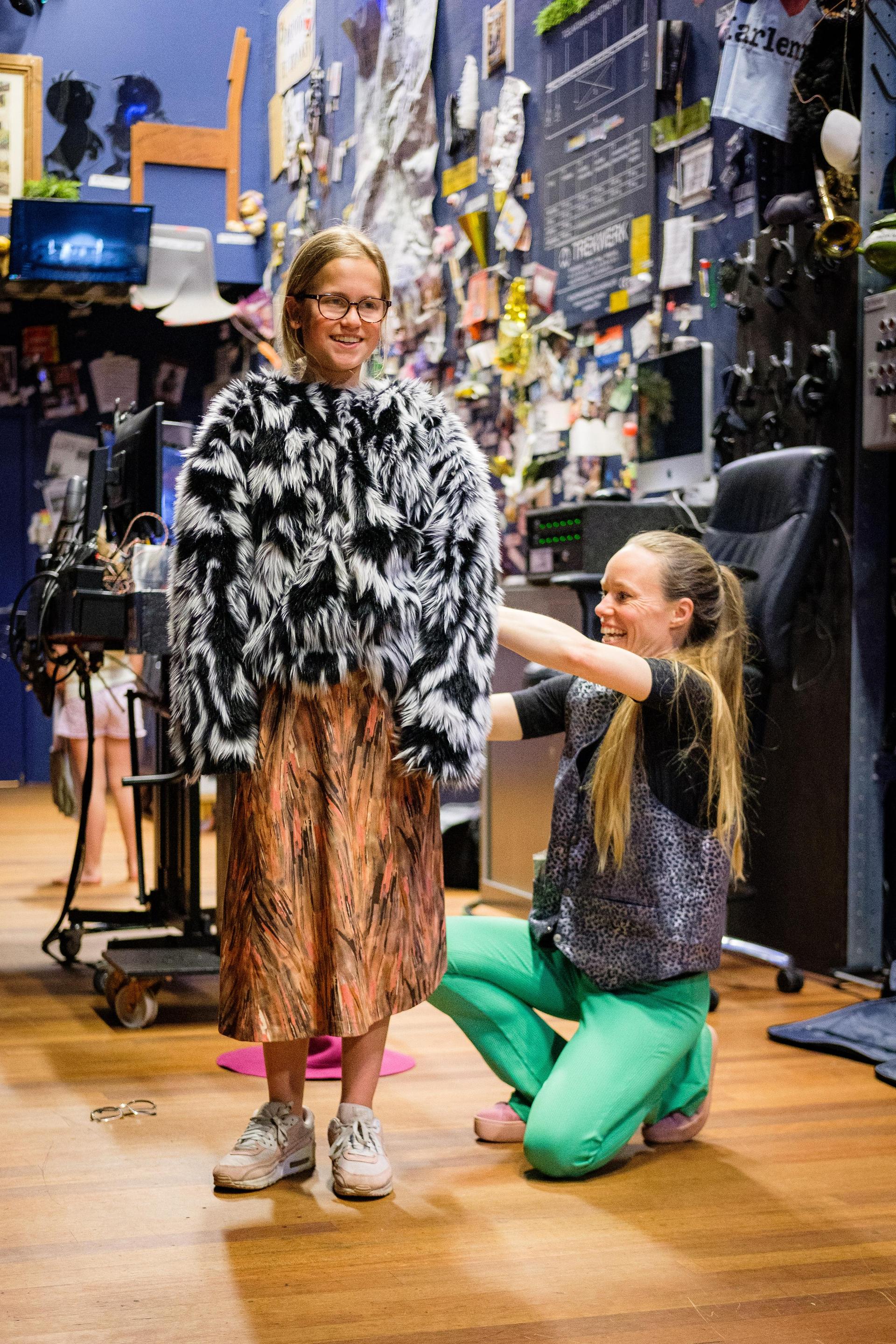 Theaterleerling wordt gekleed door theaterdocent